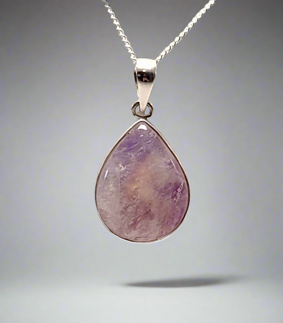 A teardrop-shaped moonstone pendant set in 925 sterling silver, included with a chain, against a grey background.