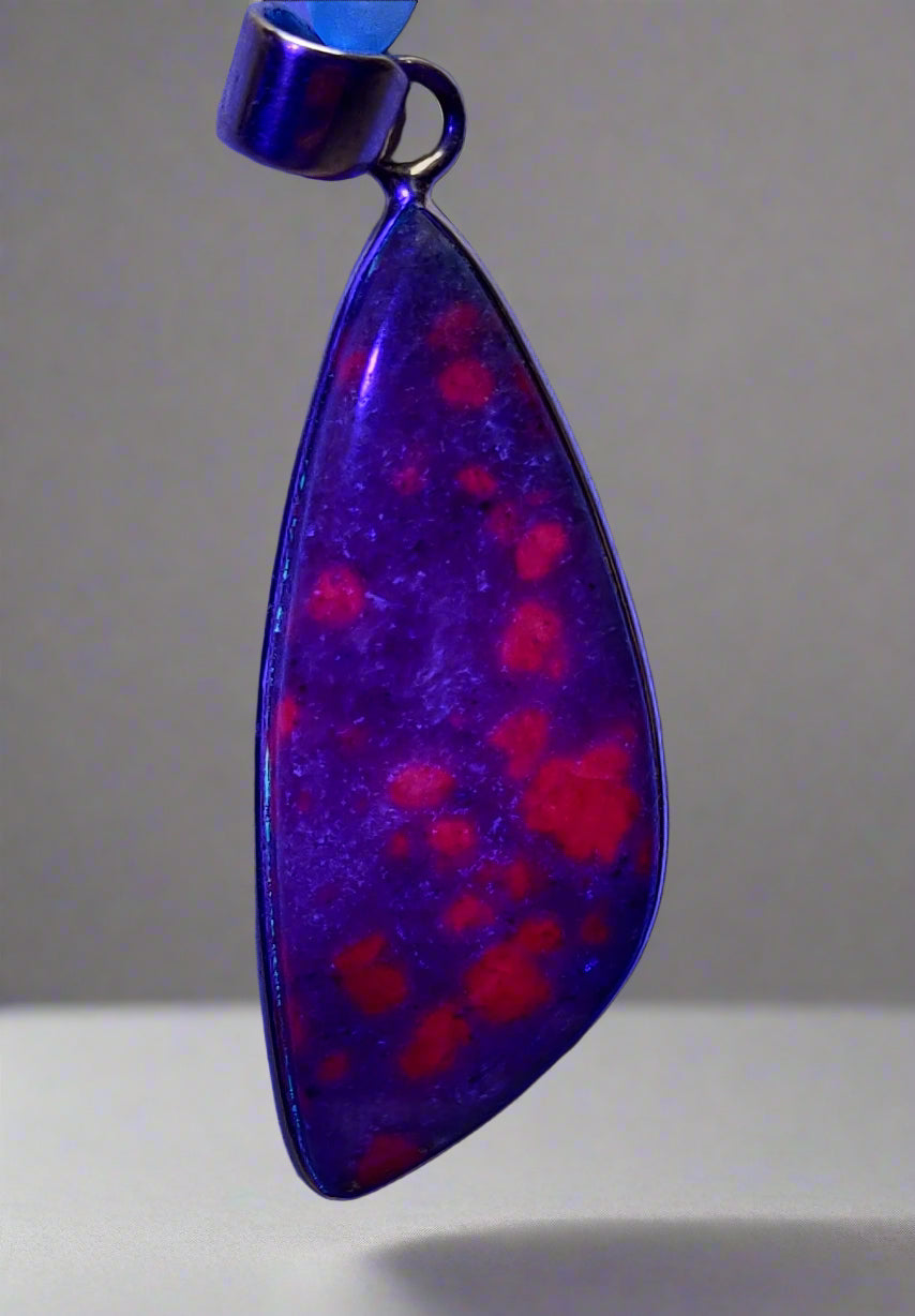 A Ruby in Kyanite pendant set in 925 sterling silver, displaying deep red and soothing blue colors.