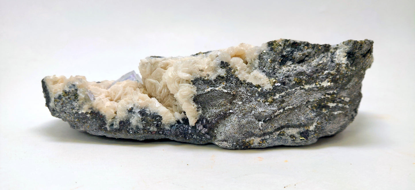 Rock with white mineral deposits on a white background