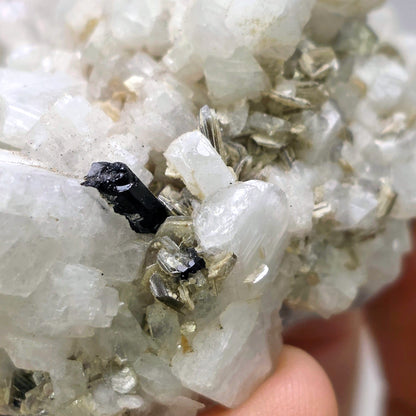 Close-up of a crystal cluster with a black mineral inclusion.
