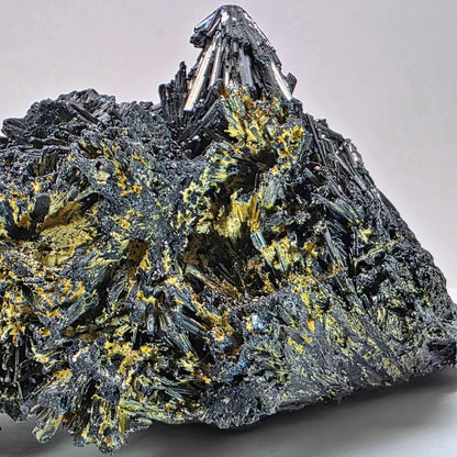 Mineral specimen with prominent crystal formations on a gray background