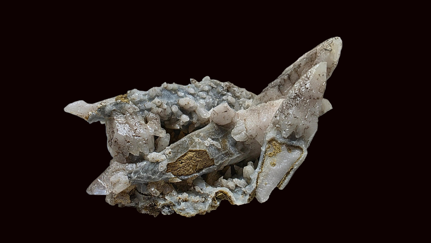 A natural mineral specimen featuring pale pinkish-white quartz crystals and clusters with gray matrix and small gold-colored inclusions, displayed on a neutral light gray background.