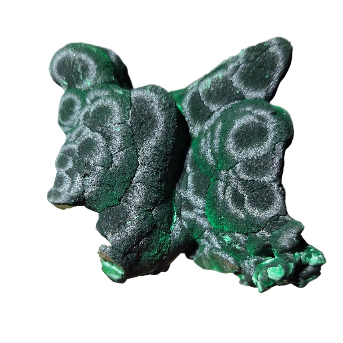 A hand holding a small, sculpted figurine of a frog made from textured green and black stone or resin with a mottled, organic pattern.