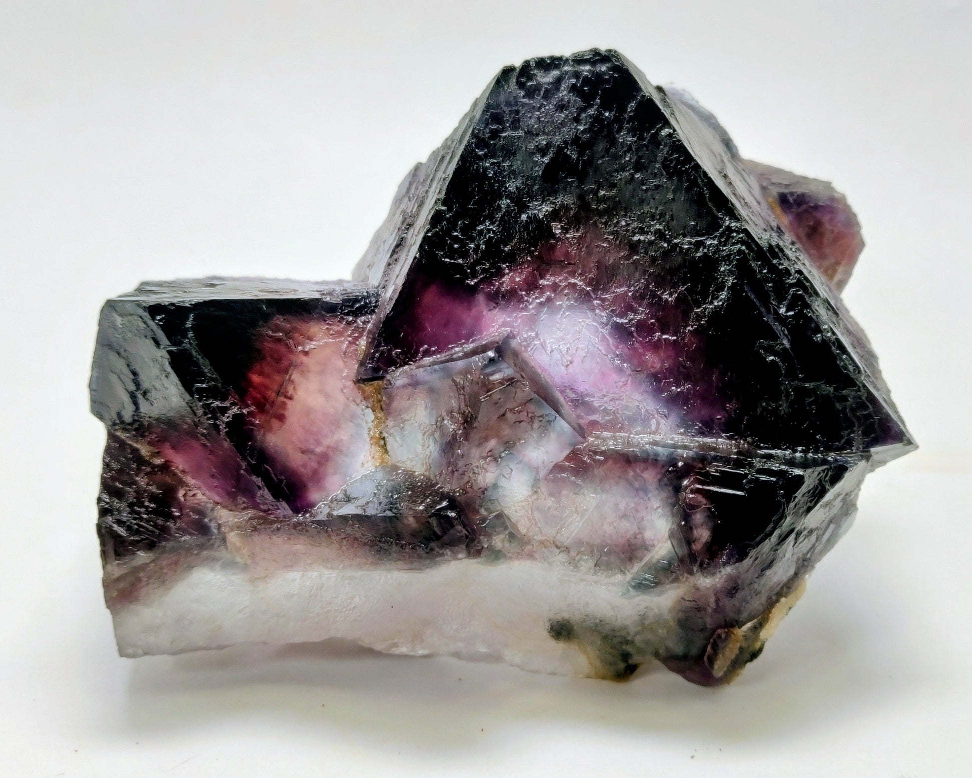 Mineral specimen with purple and black coloration on a white background