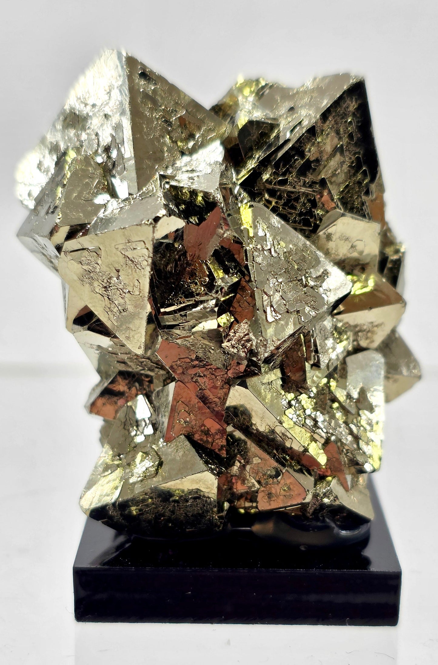 Pyrite crystal on a black base with a white background