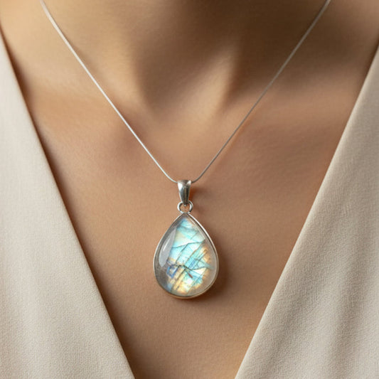 Teardrop-shaped pendant necklace on a mannequin with a beige top.