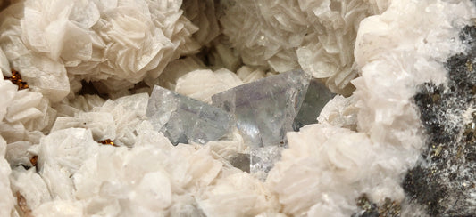 Close-up of crystalline mineral formation with a clear crystal embedded.