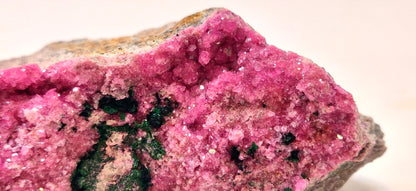 Close-up of a pink mineral crystal on a white background