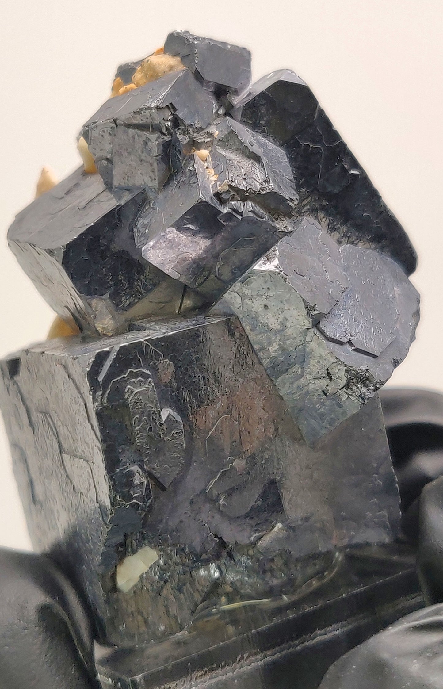 Close-up of dark-colored mineral crystals on a light background