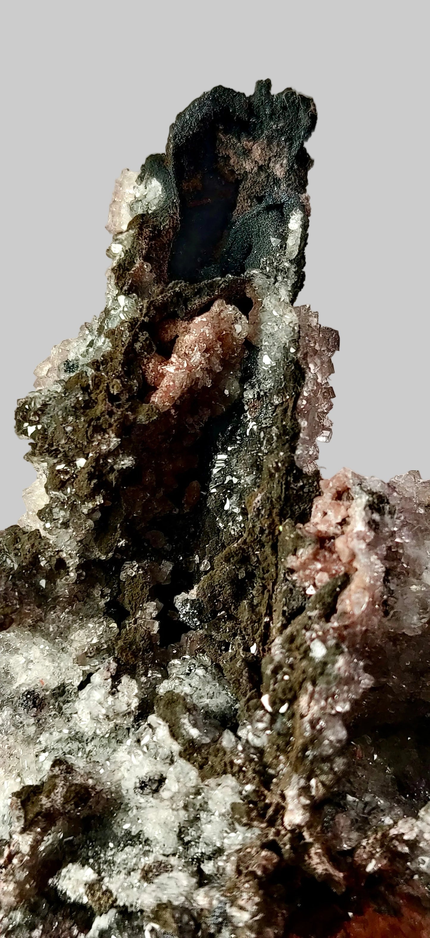 Mineral specimen with dark and light gray textures on a white background