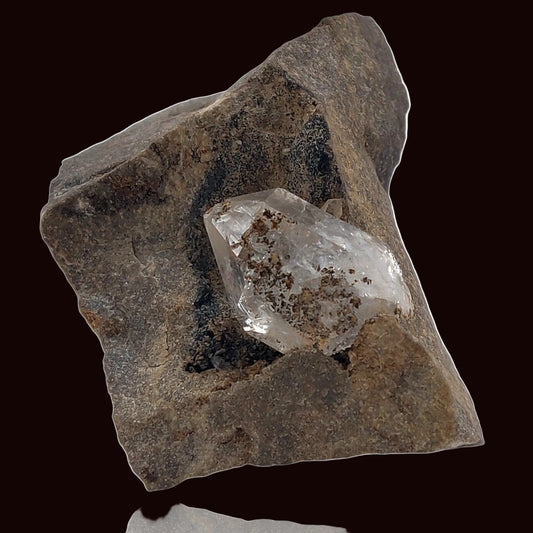 Crystal embedded in a rough stone on a white background