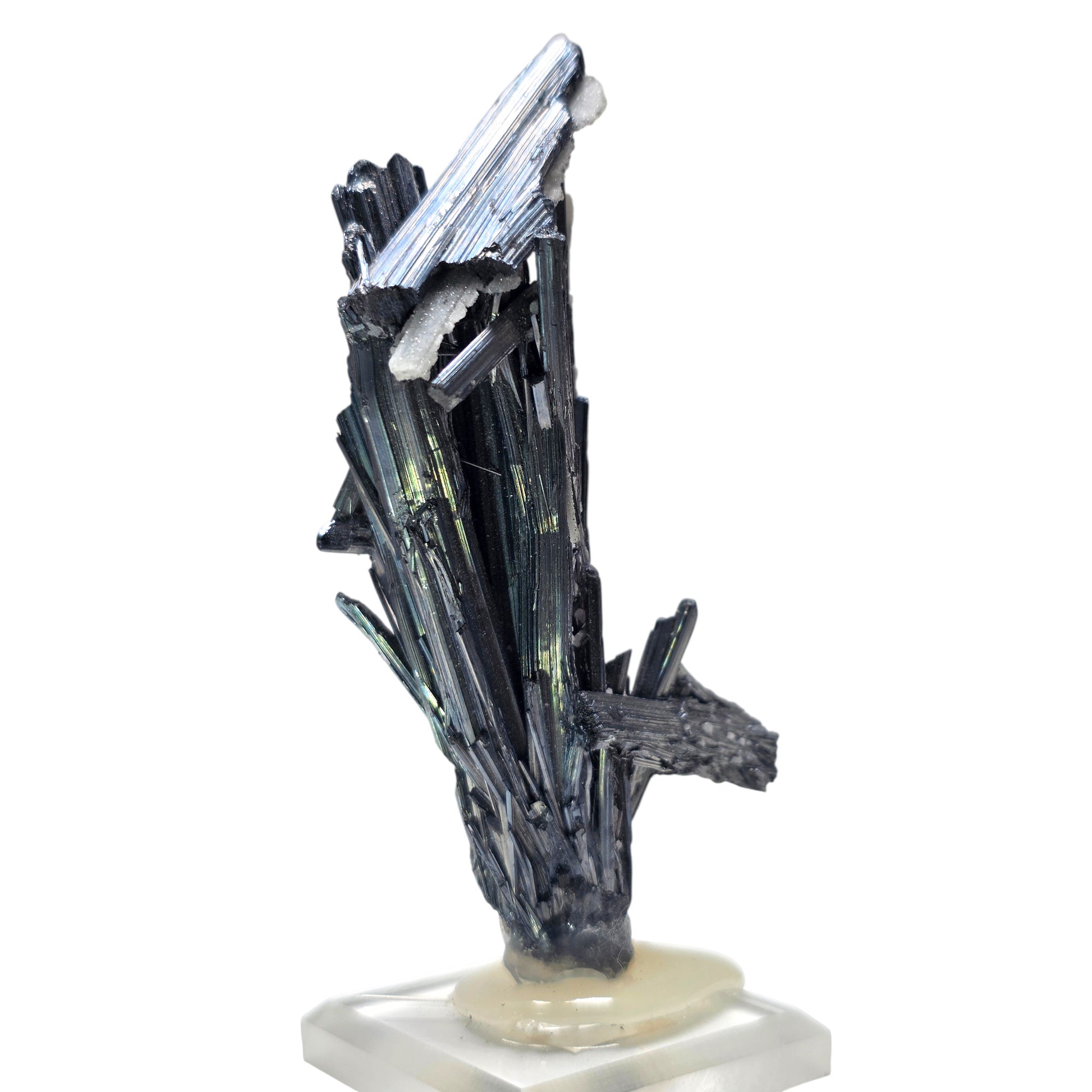 A natural mineral crystal cluster featuring dark metallic black and gray rods with iridescent green and blue sheen, mounted on a small beige stone base.